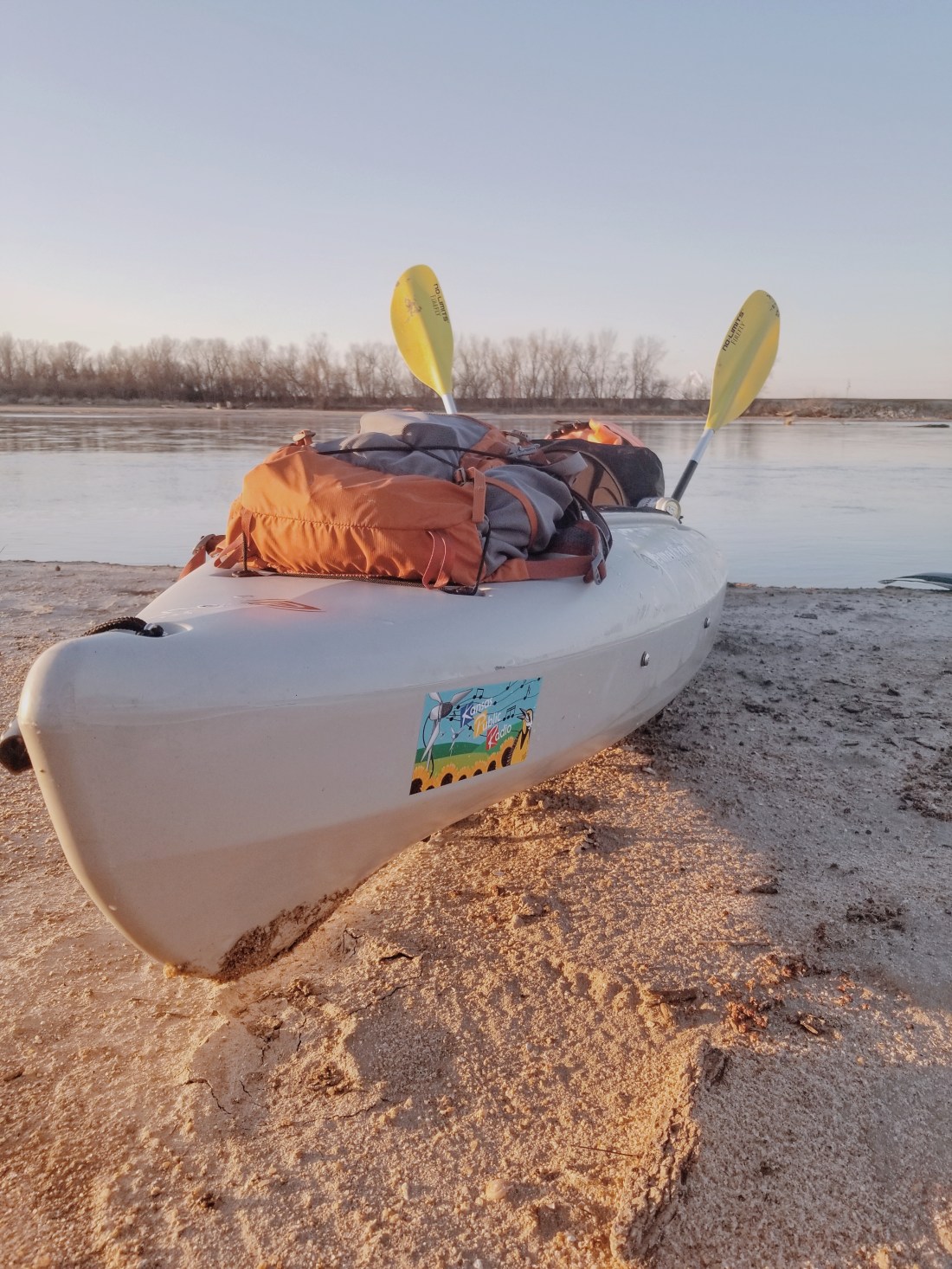 A kayak featuring the Kansas River behind it.